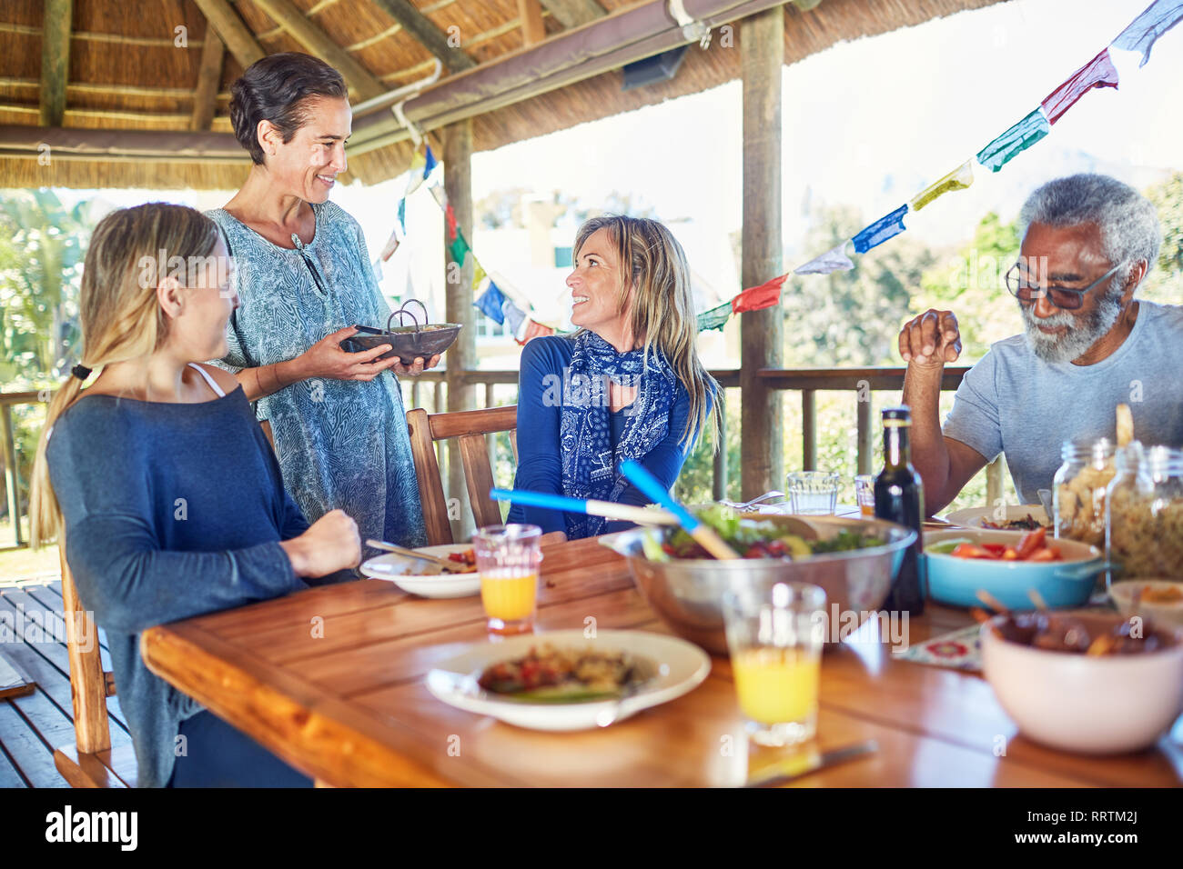 Freunde genießen gesunde Mahlzeit in der Hütte während Yoga Retreat Stockfoto