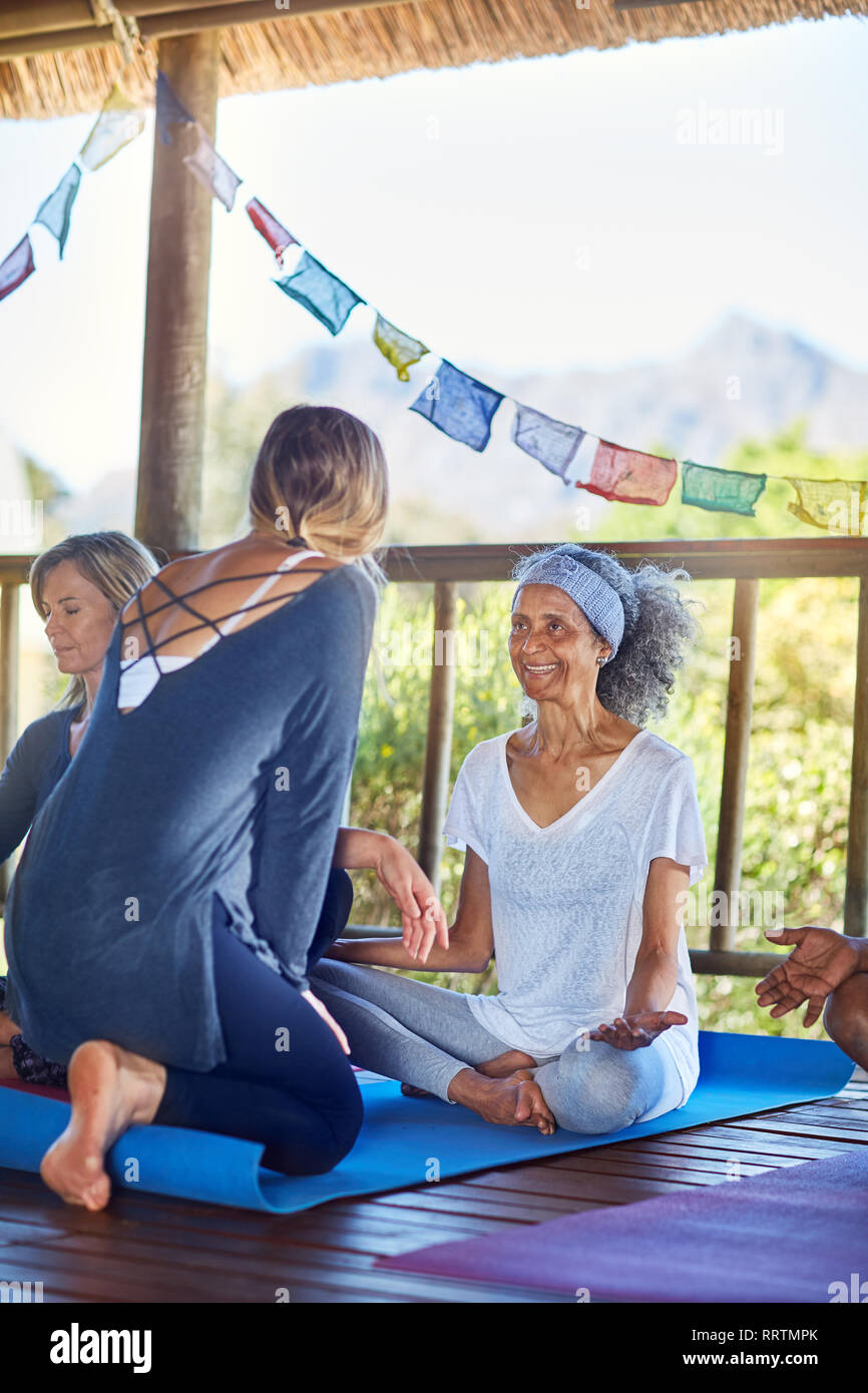 Weibliche Ausbilder im Gespräch mit Studenten in der Hütte während Yoga Retreat Stockfoto
