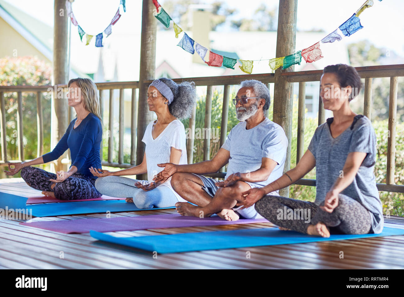 Heitere Menschen meditieren in der Hütte während Yoga Retreat Stockfoto