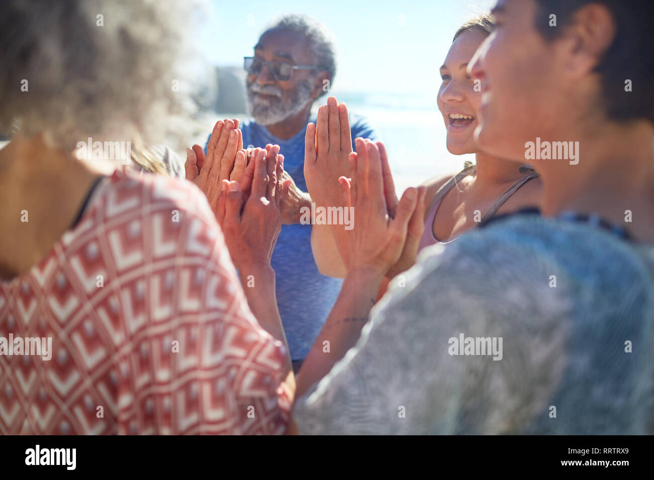 Freunde mit gefalteten Händen im Kreis genießen Yoga Retreat Stockfoto
