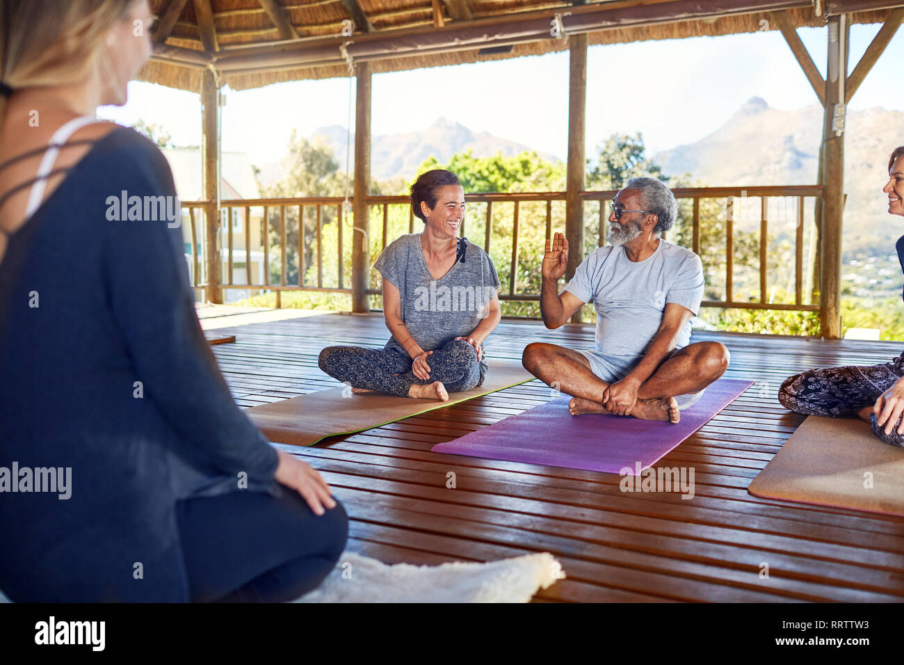 Mann und Frau sprechen während der Yogastunde in der Hütte auf Yoga Retreat Stockfoto