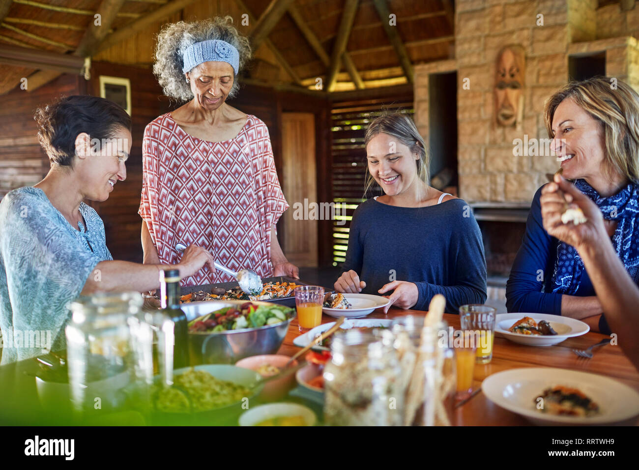 Freunde genießen gesunde Mahlzeit in der Hütte während Yoga Retreat Stockfoto