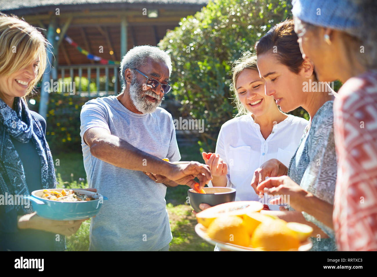Freunde genießen Sie gesunde Nahrung außerhalb sonnige Hütte während Yoga Retreat Stockfoto