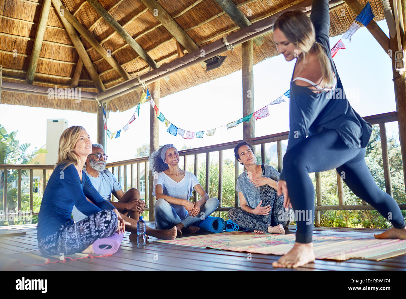 Weibliche Kursleiter zeigen Seite Winkel in der Hütte während Yoga Retreat darstellen Stockfoto
