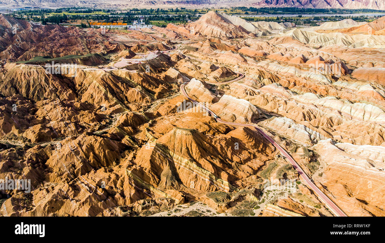 Blick von oben auf die Rainbow Bergen geologischen Park. Stripy Zhangye Danxia Relief geologischen Park in der Provinz Gansu, China. Drone Bild von Touristenbussen Stockfoto