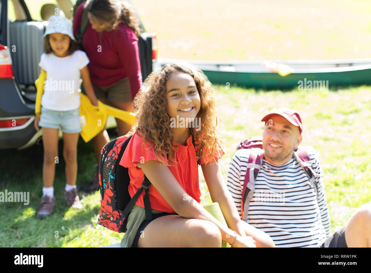 Portrait Happy girl Camping mit der Familie, entladen Auto im sonnigen Bereich Stockfoto