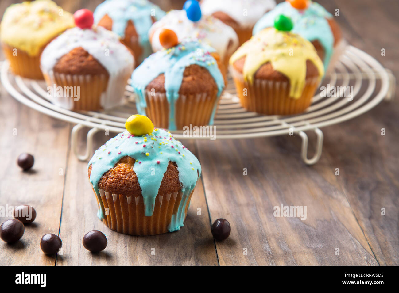Ostern oder Geburtstag cupcakes glasiert mit bunten Zucker, besprüht und Schokolade für die Kinder Partei auf einem rustikalen Holztisch Stockfoto
