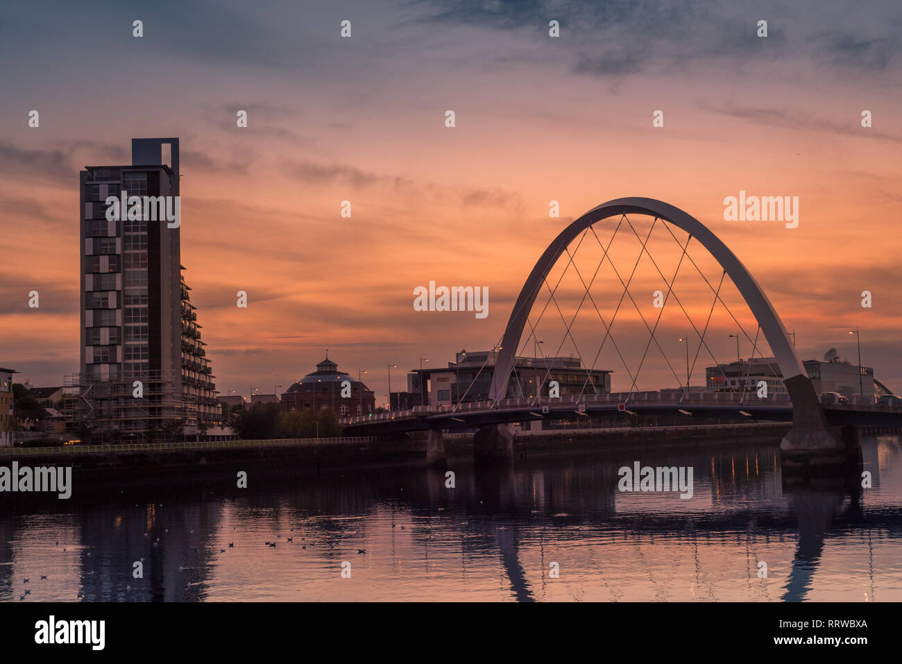 Glasgow/Schottland - 20. September 2016: Die Clyde Arc und die umliegenden Gebäude gegen eine orange Sonnenuntergang über dem Fluss Clyde Stockfoto