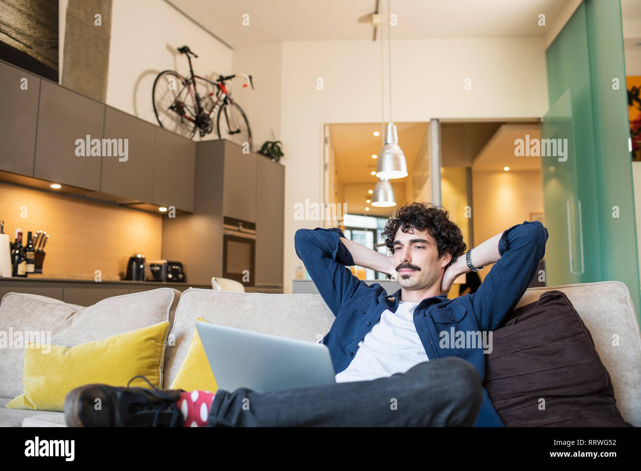 Mann entspannt auf Apartment Sofa Stockfoto