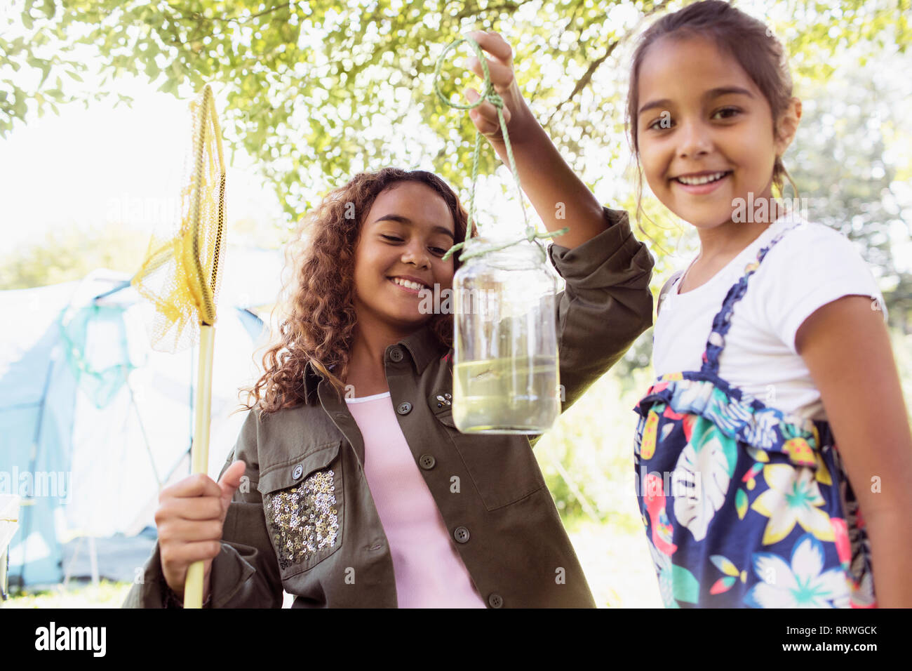 Portrait happy Schwestern Fisch im Glas fangen Stockfoto