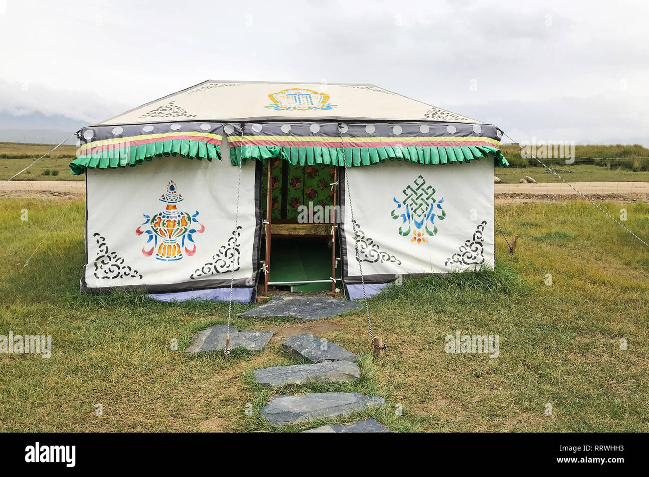 Ein Quadrat Jurte Zelt. Eingang zu einem Traditionellen mongolischen Nomaden Hütte. Einem orientalischen authentische Tibetische Haus. Eine offene Tür in ein temporäres Yugur Haus. Stockfoto
