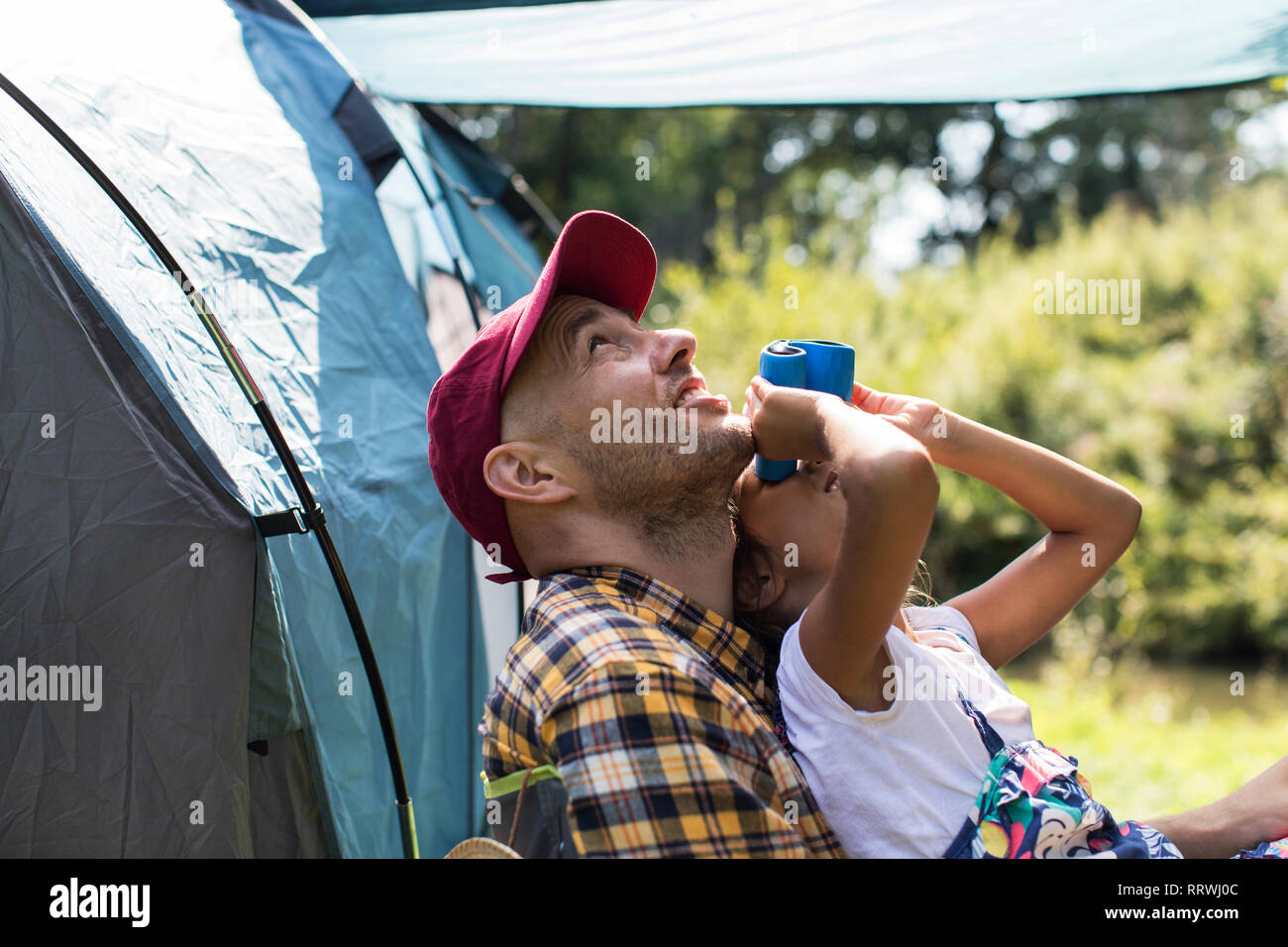 Neugierig Vater und Tochter Vogelbeobachtung Mit dem Fernglas bei Sunny Campingplatz Stockfoto