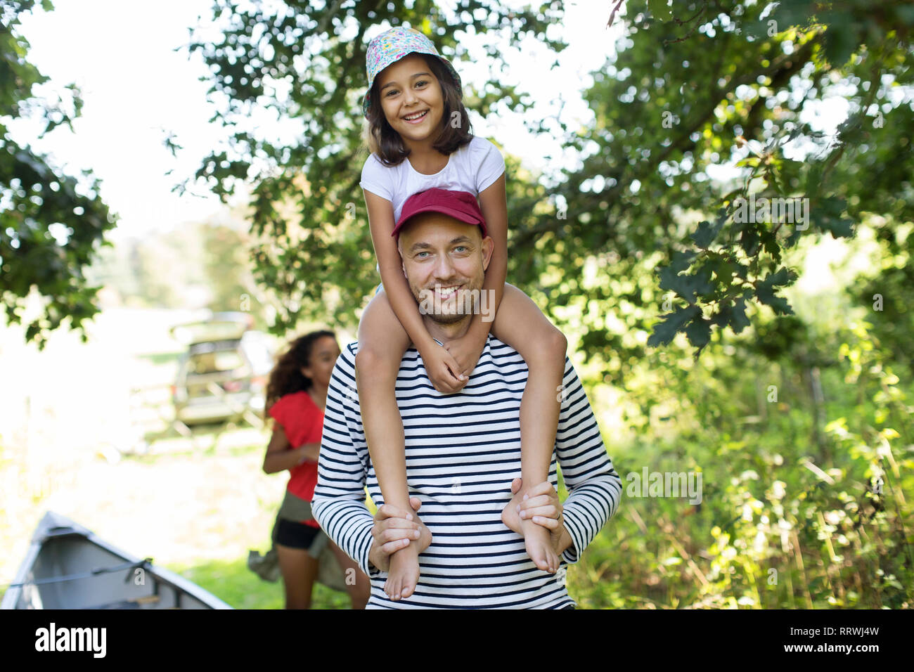 Portrait Vater mit Tochter auf Schultern in Holz Stockfoto