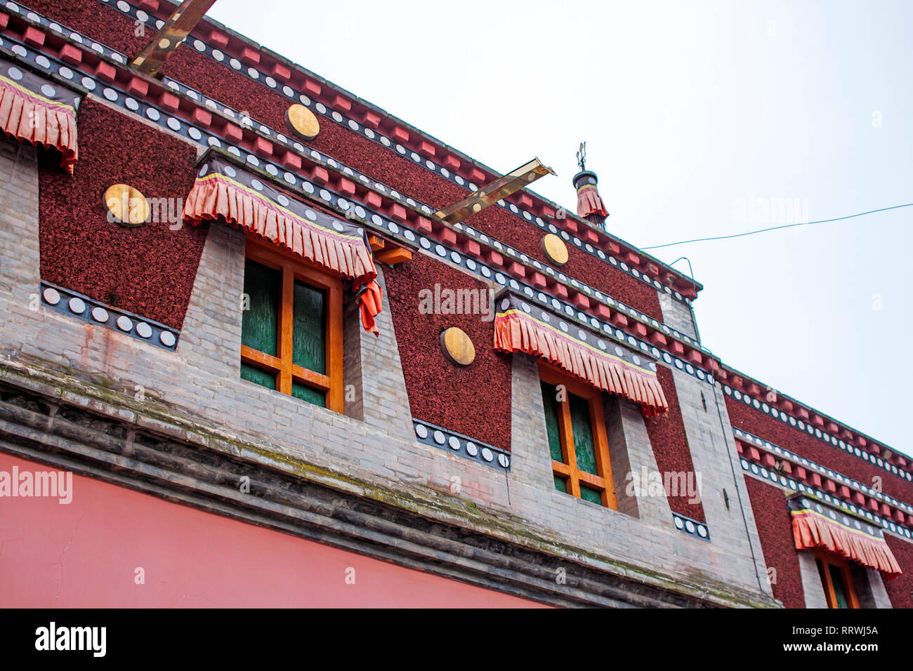 Bunte tibetischer Architektur. Detaillierte Fassade des obersten Etage des Traditionellen buddhistischen Gebäude. Rote chinesische Windows. Stockfoto