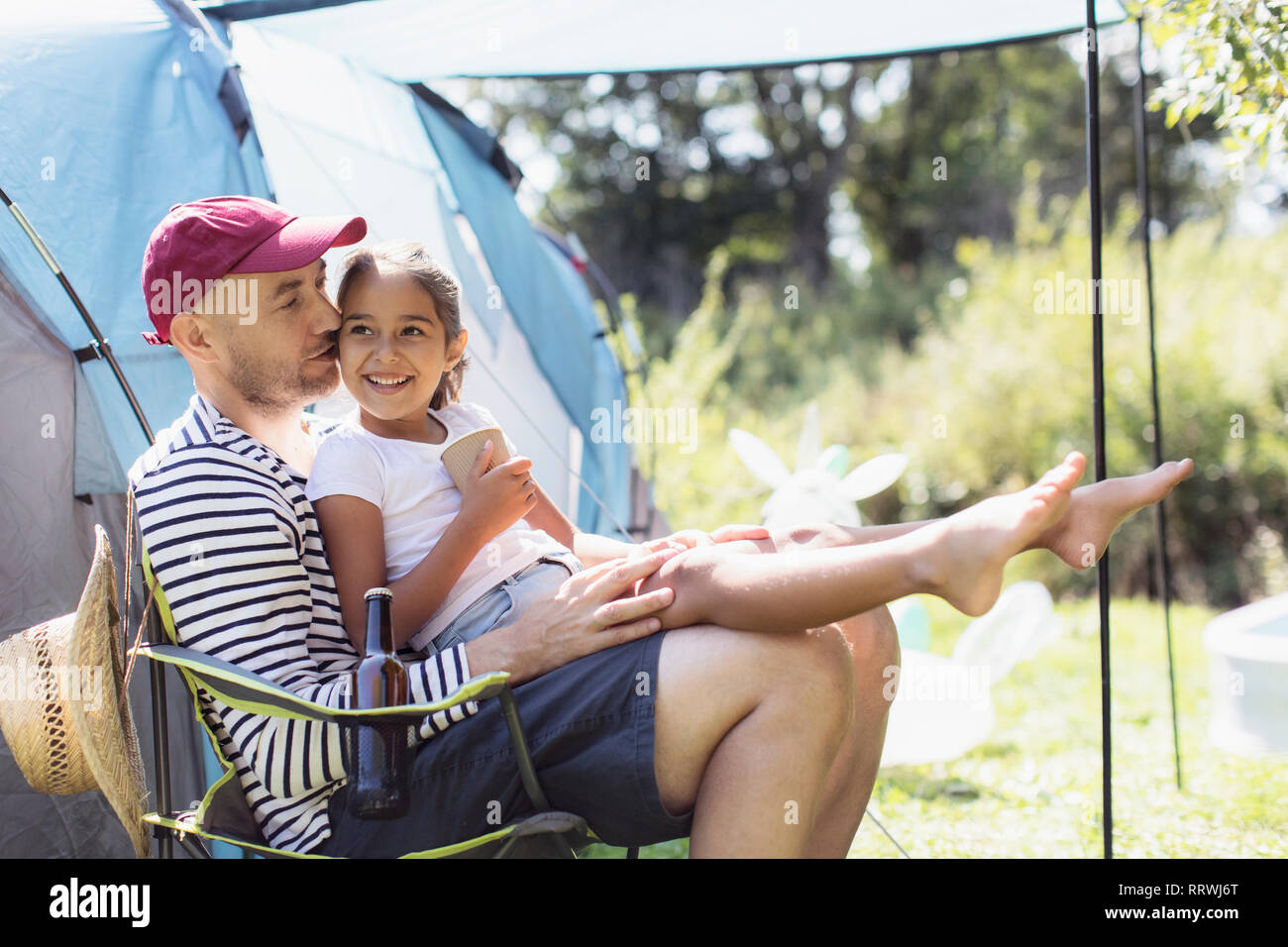 Glücklich, liebevoller Vater Holding Tochter in der Runde an sonnige Campingplatz Stockfoto