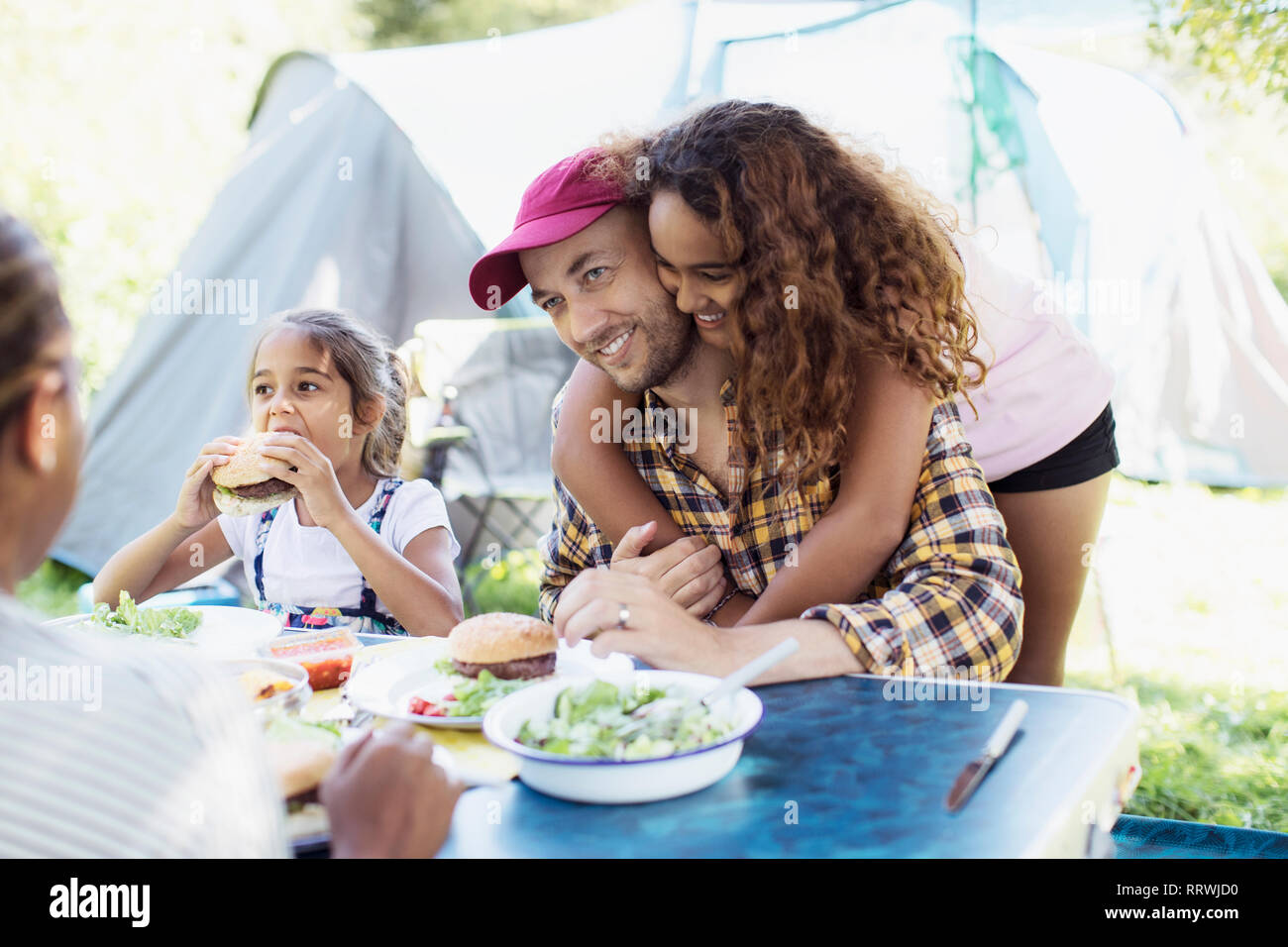 Liebevolle Tochter umarmt Vater das Mittagessen auf dem Campingplatz Stockfoto