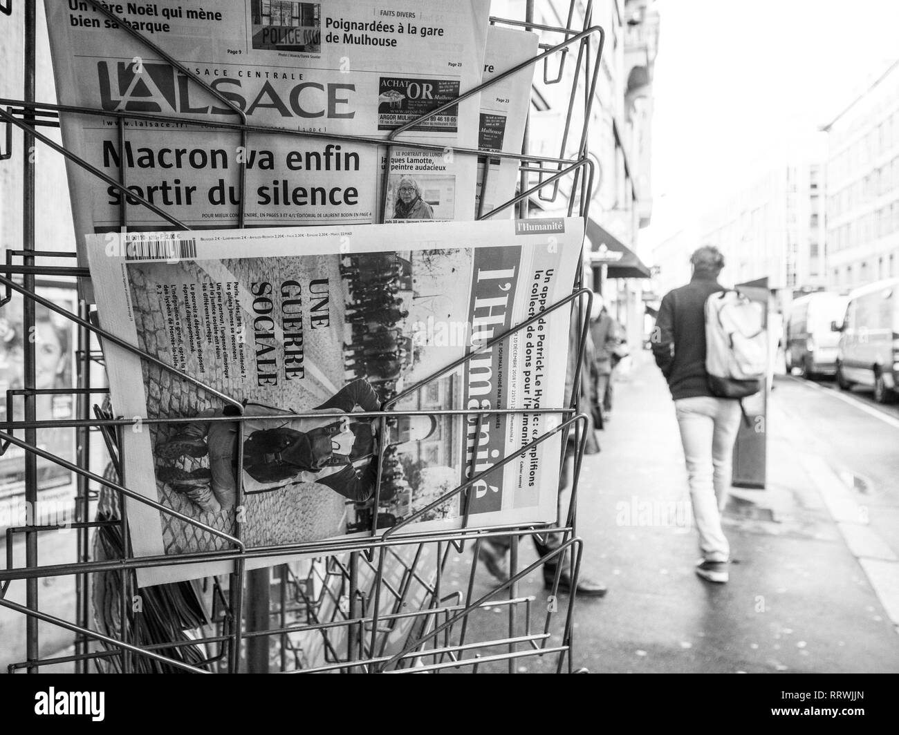 PARIS, Frankreich, 10.Dezember, 2018: Zeitungskiosk kiosk Presse Vertrieb mit mehreren Zeitung mit Nachrichten über die Ereignisse in Frankreich und der Fußgängerzone Silhouetten ruhig laufen im Hintergrund - Schwarz und Weiß Stockfoto