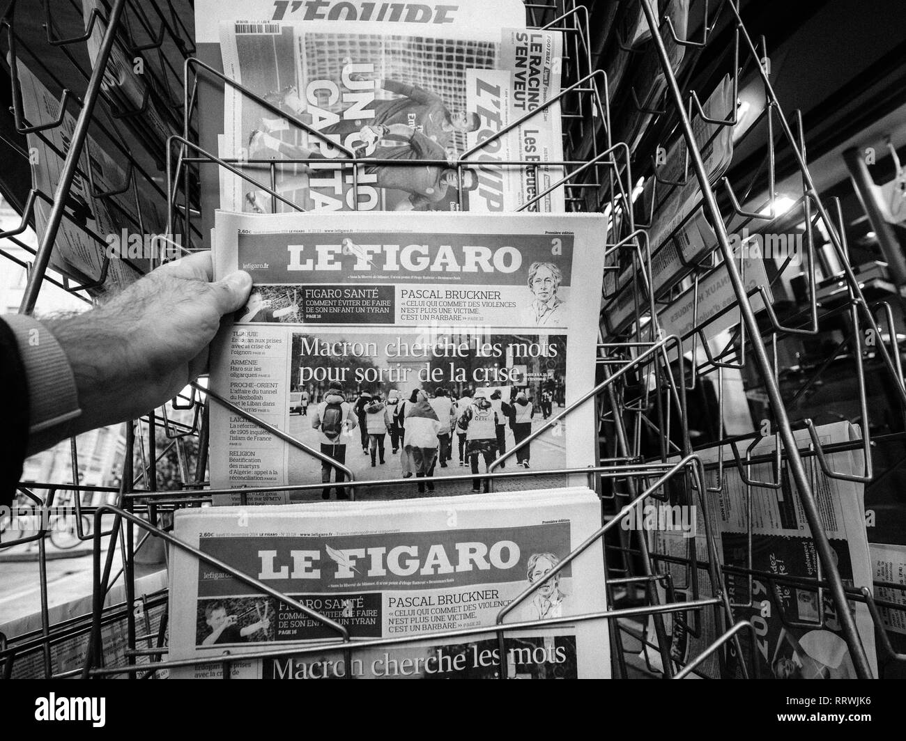 PARIS, Frankreich, 10.Dezember, 2018: Zeitungskiosk kiosk Presse verkaufen mit Hand kaufen Le Figaro mit Titel Längestrich Suche nach Wörtern zu verlassen Krise Stockfoto