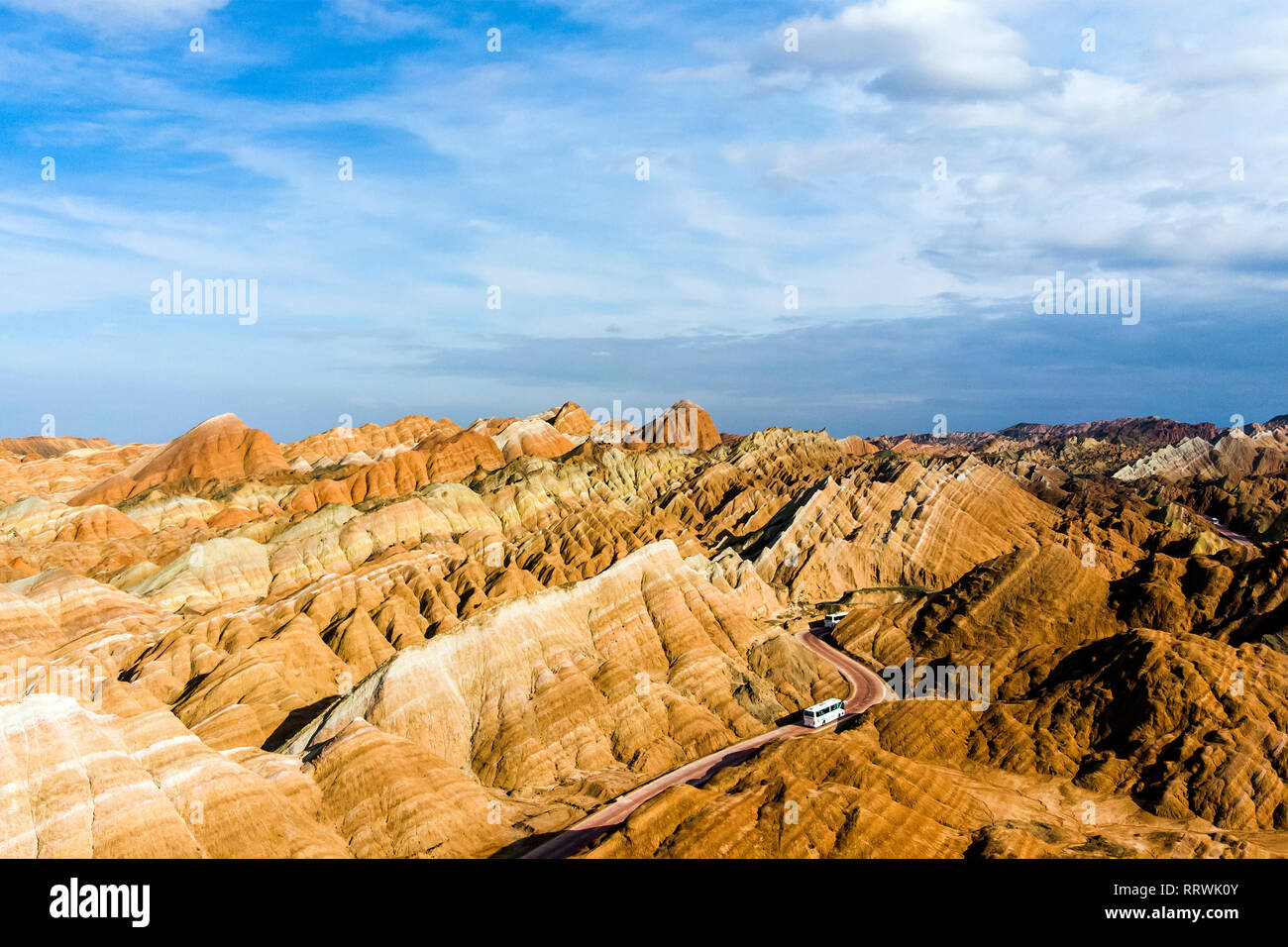 Blick von oben auf die Rainbow Bergen geologischen Park. Stripy Zhangye Danxia Relief geologischen Park in der Provinz Gansu, China. Drone Bild von Touristenbussen Stockfoto