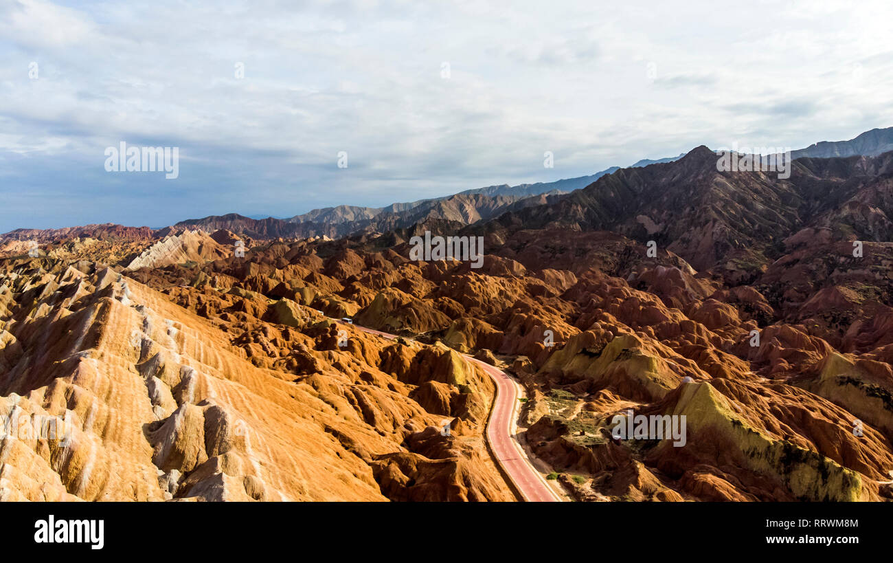 Blick von oben auf die Rainbow Bergen geologischen Park. Stripy Zhangye Danxia Relief geologischen Park in der Provinz Gansu, China. Drone Bild von Touristenbussen Stockfoto