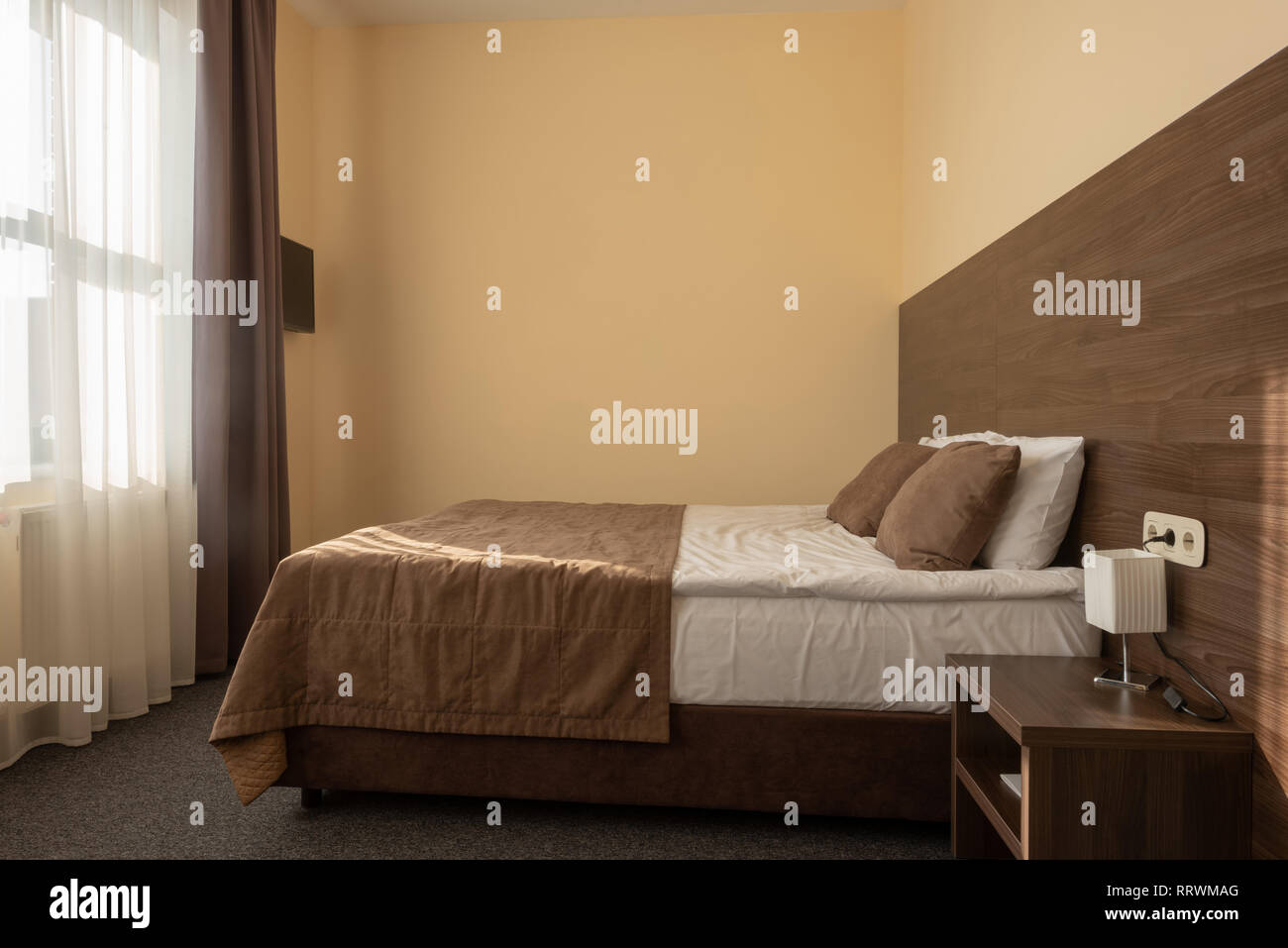 Modernes Hotel, Schlafzimmer mit Bett in brauner Farbe Stockfoto