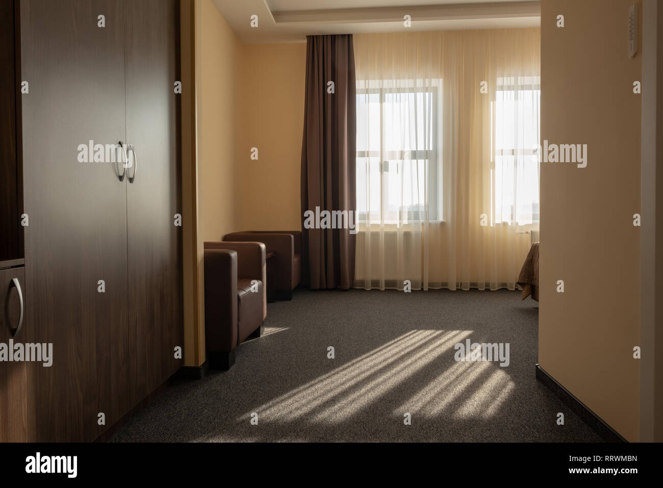 Hotel Zimmer mit Kleiderschrank, Sessel und Fenster Stockfoto