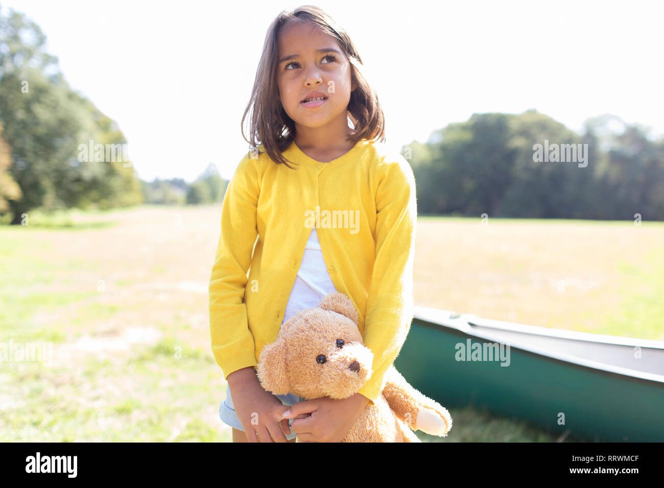 Mädchen mit Teddybär im sonnigen Bereich mit canoe Stockfoto