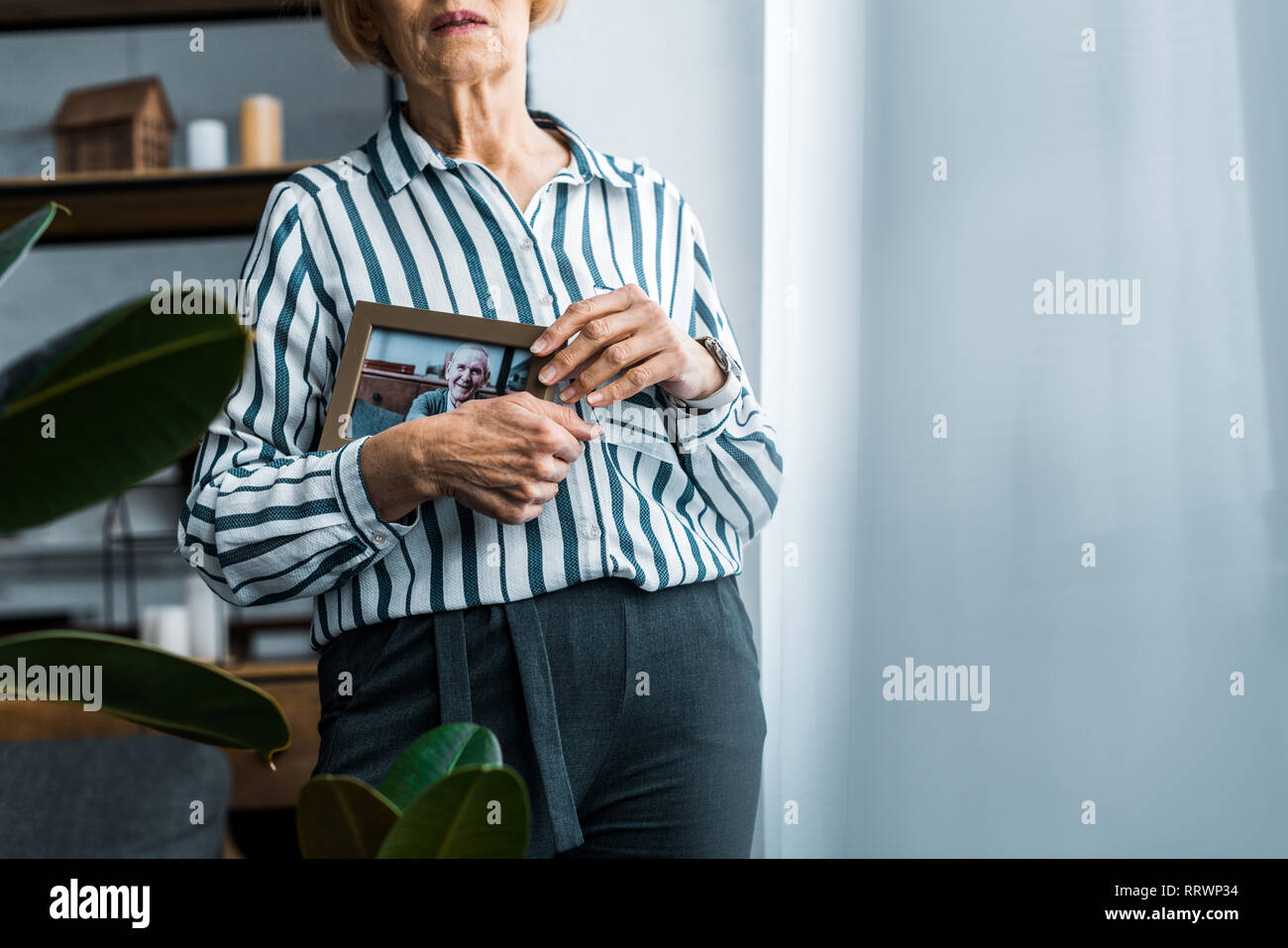 Teilweise mit Blick auf die ältere Frau mit Rahmen mit Mann auf Foto zu Hause mit Platz kopieren Stockfoto