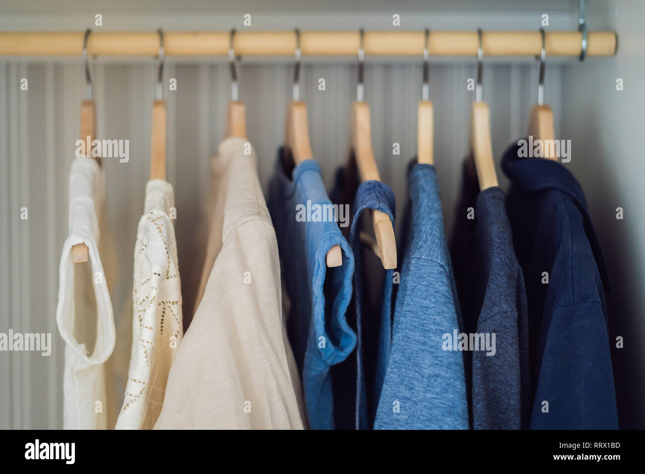 Kleidung auf Kleiderbügel im Schrank Farbverlauf von Weiß bis Dunkelblau  Stockfotografie - Alamy