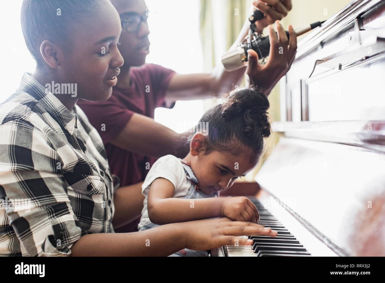 Bruder und Schwestern Klavier spielen Stockfoto