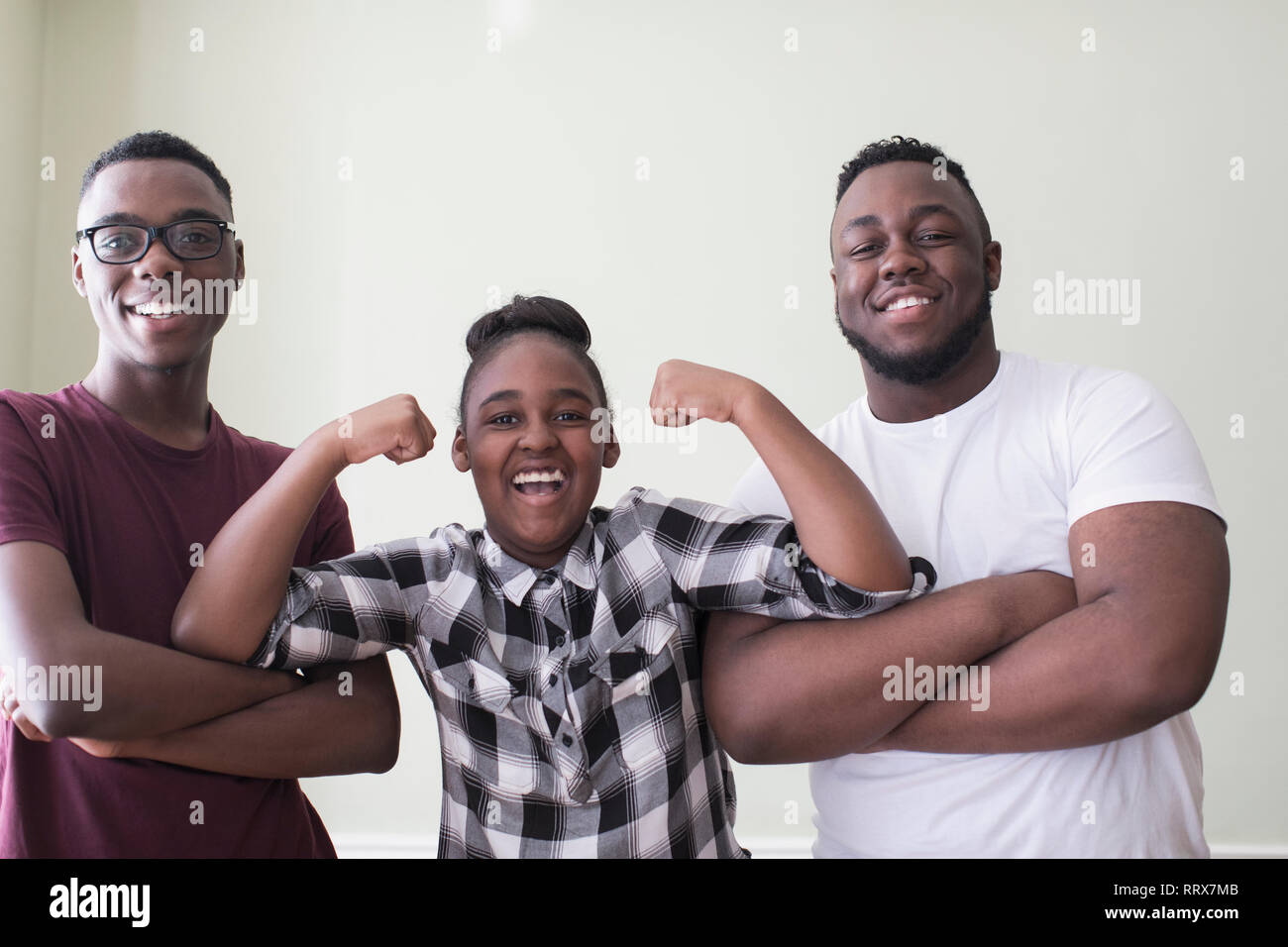 Portrait zuversichtlich teenage Brüder und Schwester flexing Muskeln Stockfoto