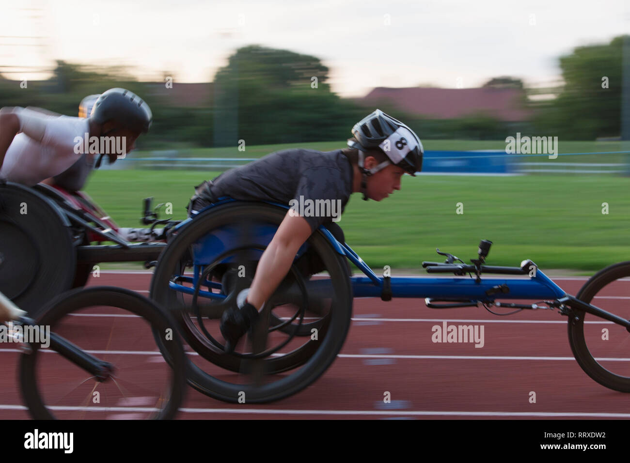 Bestimmt querschnittsgelähmte Sportler Beschleunigung zusammen Sport Track im Rollstuhl Rennen Stockfoto