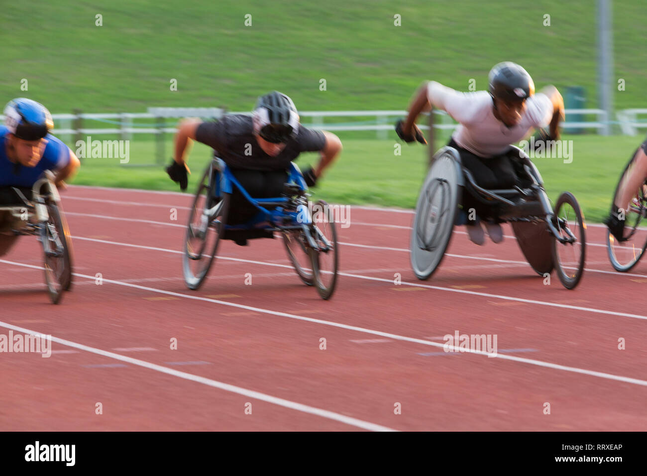 Bestimmt paraplegic Athlet Beschleunigung zusammen Sport Track im Rollstuhl Rennen Stockfoto