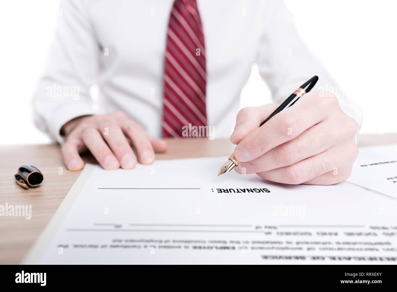 Geschäftsmann in Hemd und Krawatte ein Papier unterzeichnen Vertrag mit einem Kugelschreiber auf dem Schreibtisch Stockfoto