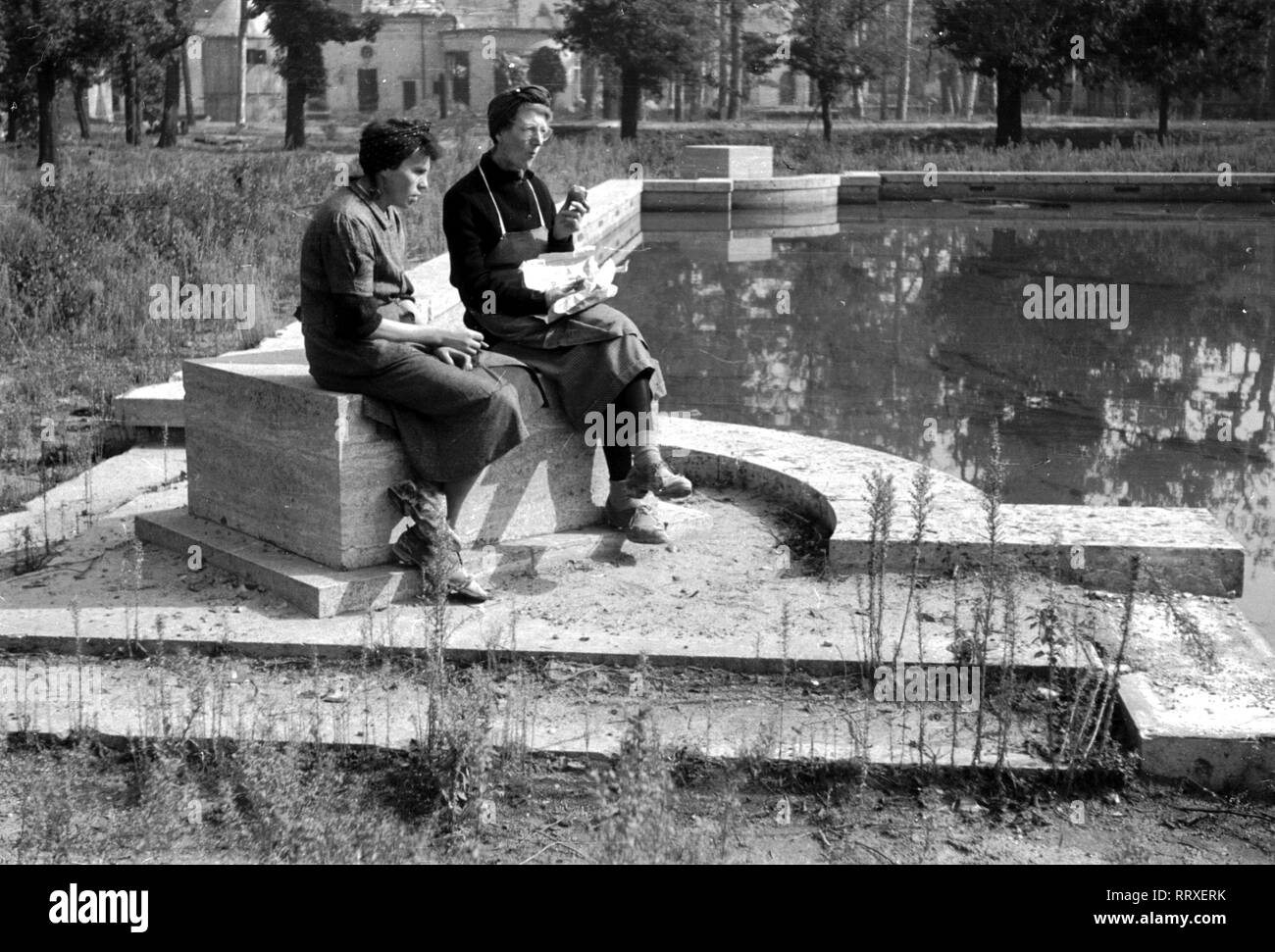 Berlin - Nachkriegsdeutschland - Berlin - Nachkriegsdeutschland, Juni 1946. Trümmerfrauen der Reichskanzlei. Zwei Frauen sitzen vor der "reichskanzlei" (1878-1945) in Berlin an einem Teich, 06/1946, I. 071-42 Stockfoto