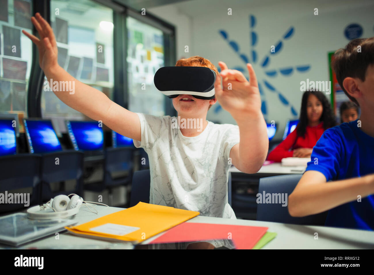 Neugierig Junior high school junge Studenten mit Virtual reality Simulator im Klassenzimmer Stockfoto