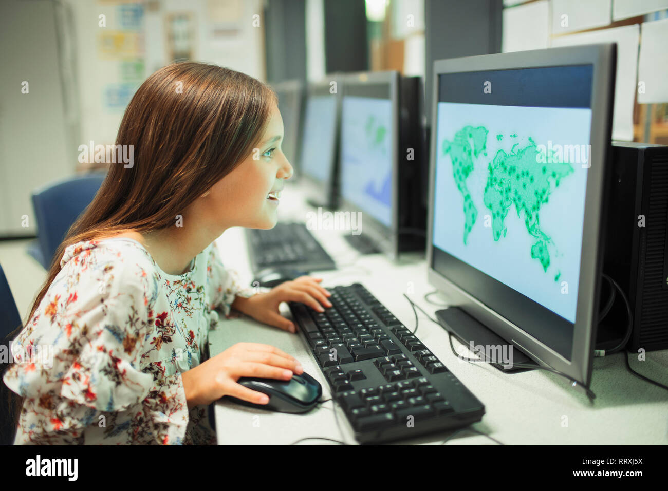 Neugierig Junior high school girl Student an der Karte auf dem Computer im Klassenzimmer auf der Suche Stockfoto