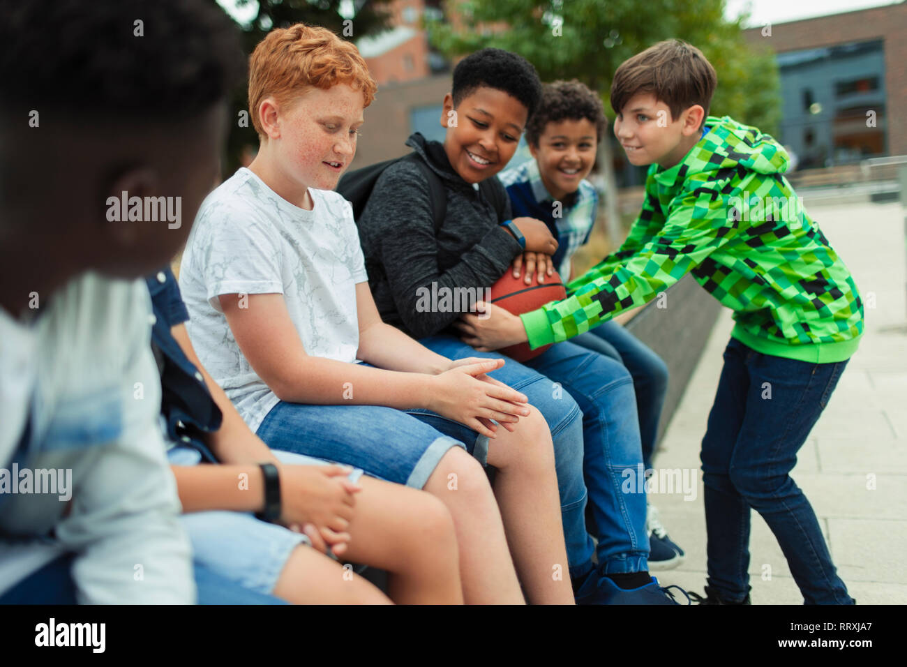 Tween Jungen mit Basketball in Schulhof Stockfoto