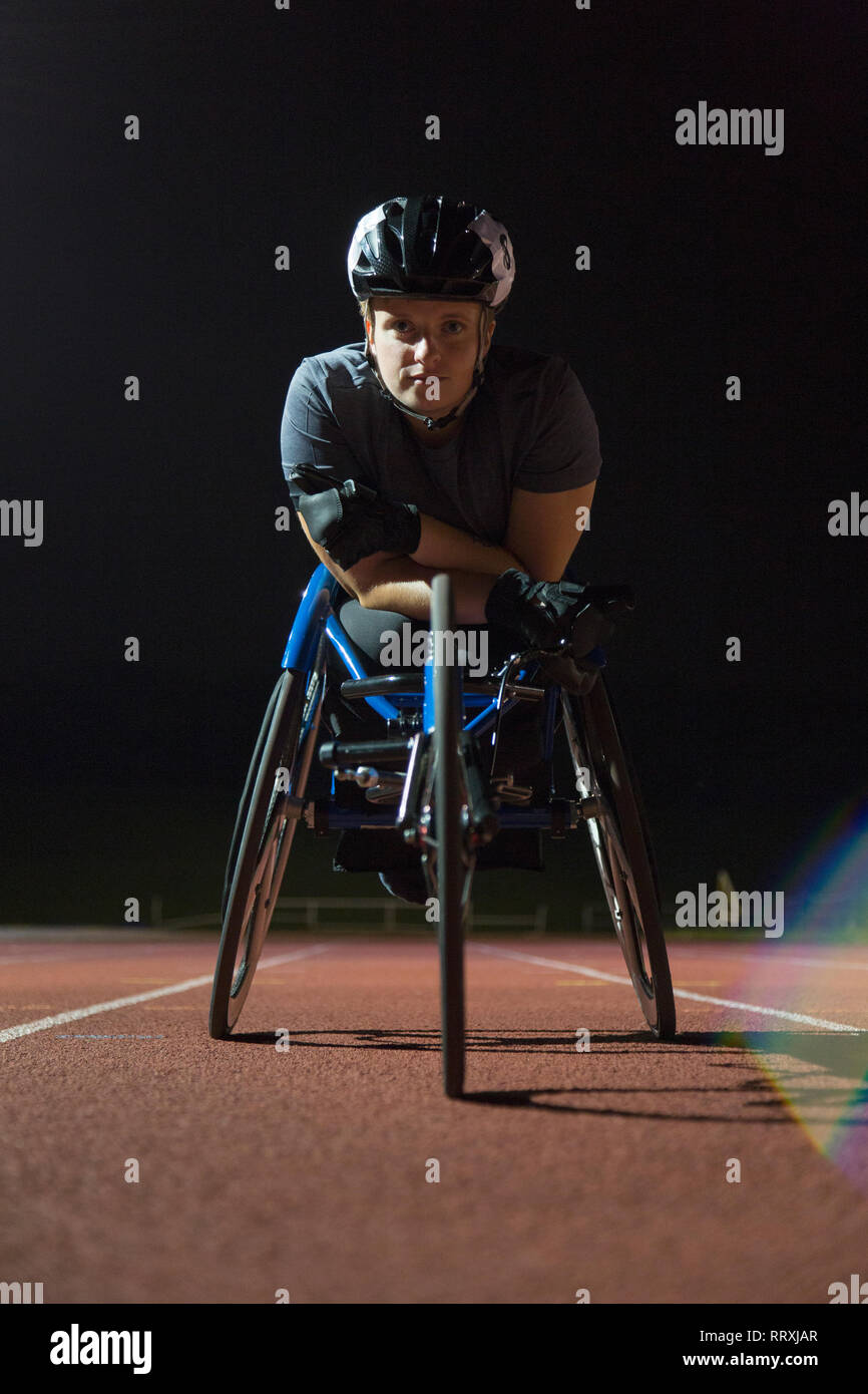 Portrait ermittelt, haltbare Junge weibliche paraplegic Athlet Training für Rollstuhl Rennen am Sportplatz in der Nacht Stockfoto