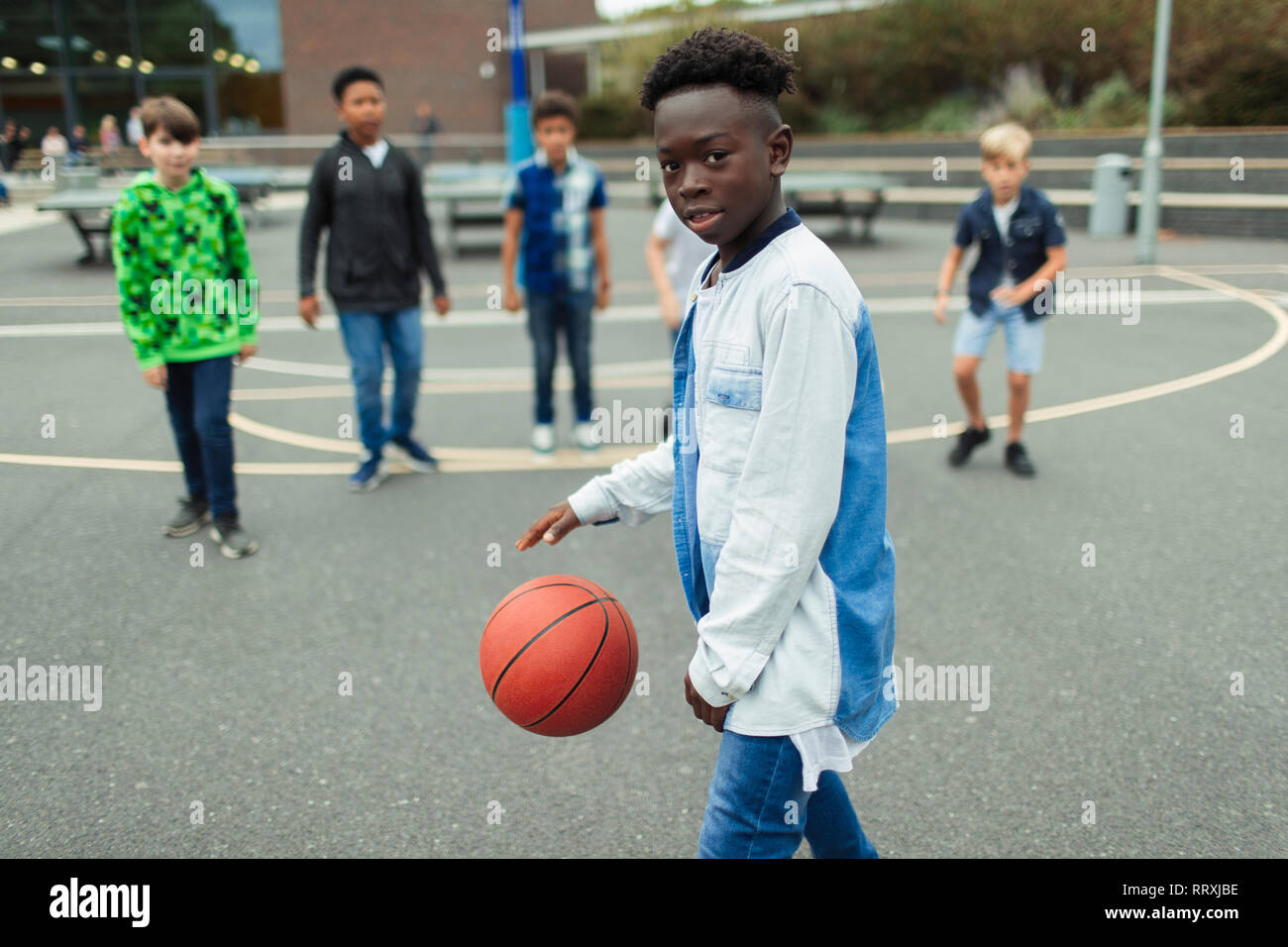 Portrait zuversichtlich Tween junge Basketball spielen im Schulhof Stockfoto