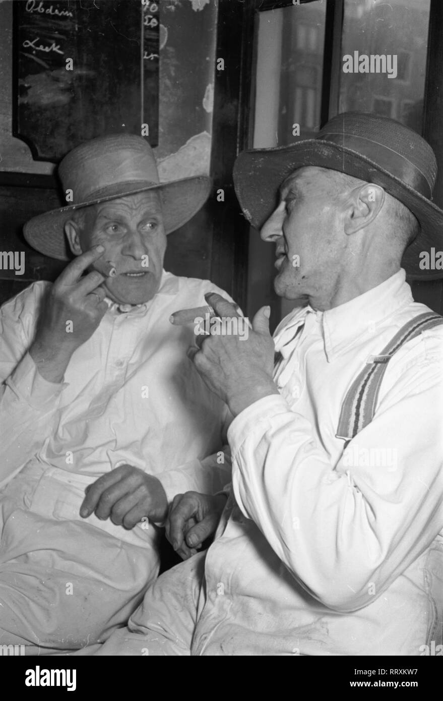 Niederlande - VI. 1235-10, NL, Raucher, Niederlande, Alkmaar, zwei käseträger im Gespräch, 1954. Zwei Käse Hersteller miteinander zu reden in Alkmaar. Stockfoto