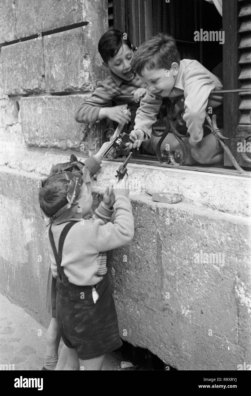 Reisen nach Italien - Italien 1950 - kleine Jungs in Rom spielen mit Spielzeug Pistolen. Kleine Jungen bekämpfen sich mit Spielzeugpistolen in Rom, Italien. Foto Erich Andres Stockfoto
