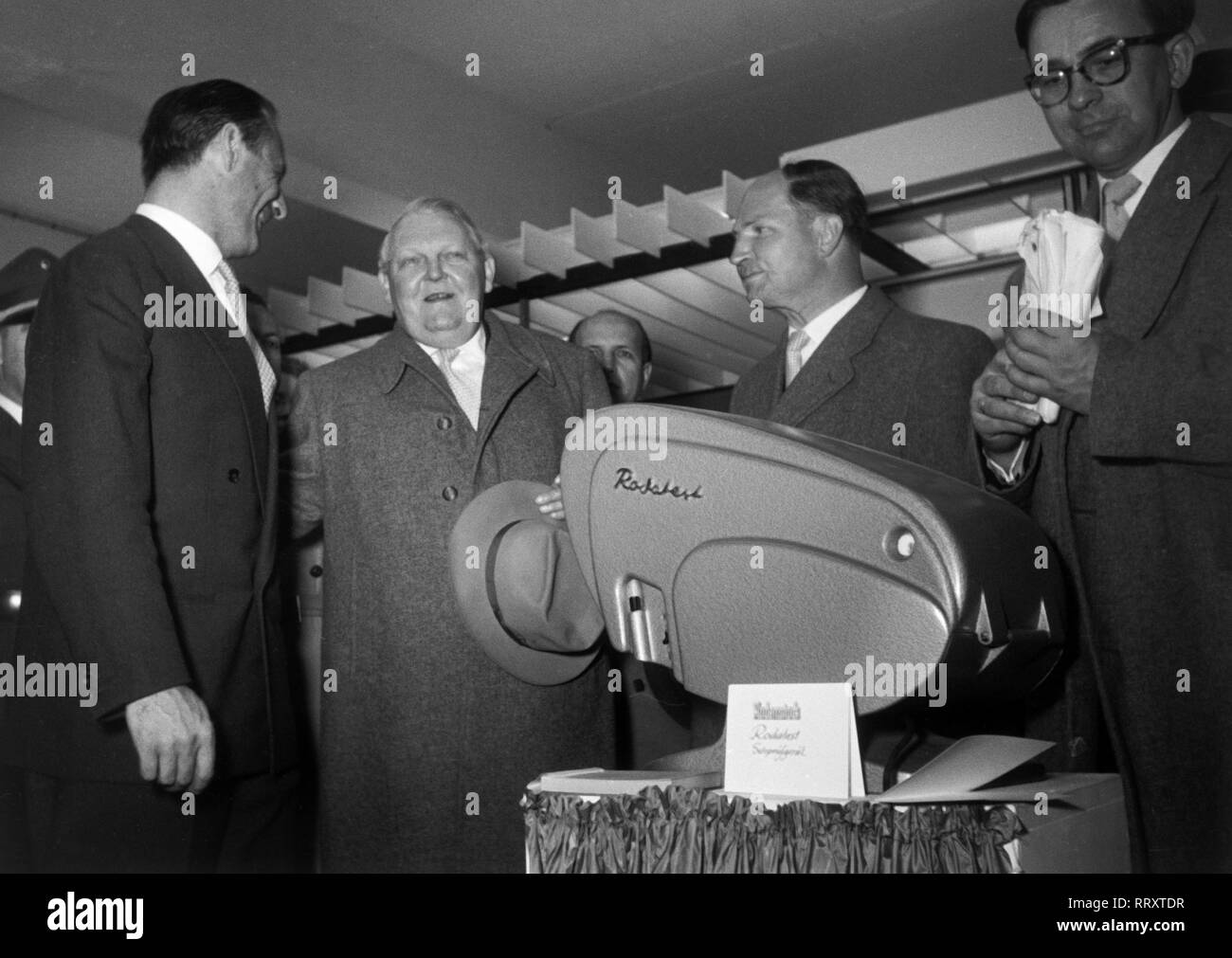 Deutschland - Deutsche Industriemesse 1956 in Hannover, Prof. Dr. Ludwig Erhard (2. v. l.) am Stand der Firma Rodenstock Rodatest Sehprüfgerät mit dm. Stockfoto