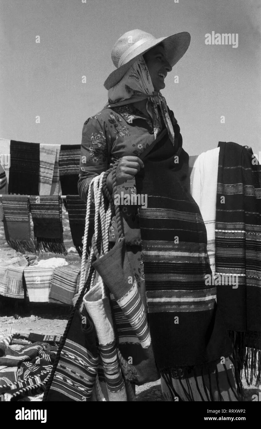 Spanien, Griechenland - Eine Frau verkauft Decken und Schals als Andenken an den 206 auf der Insel Delos, Panorama, 1950er Jahre. Eine Frau verkaufen Decken und Schals als Souvenir von Delos, Griechenland, 1950. Stockfoto