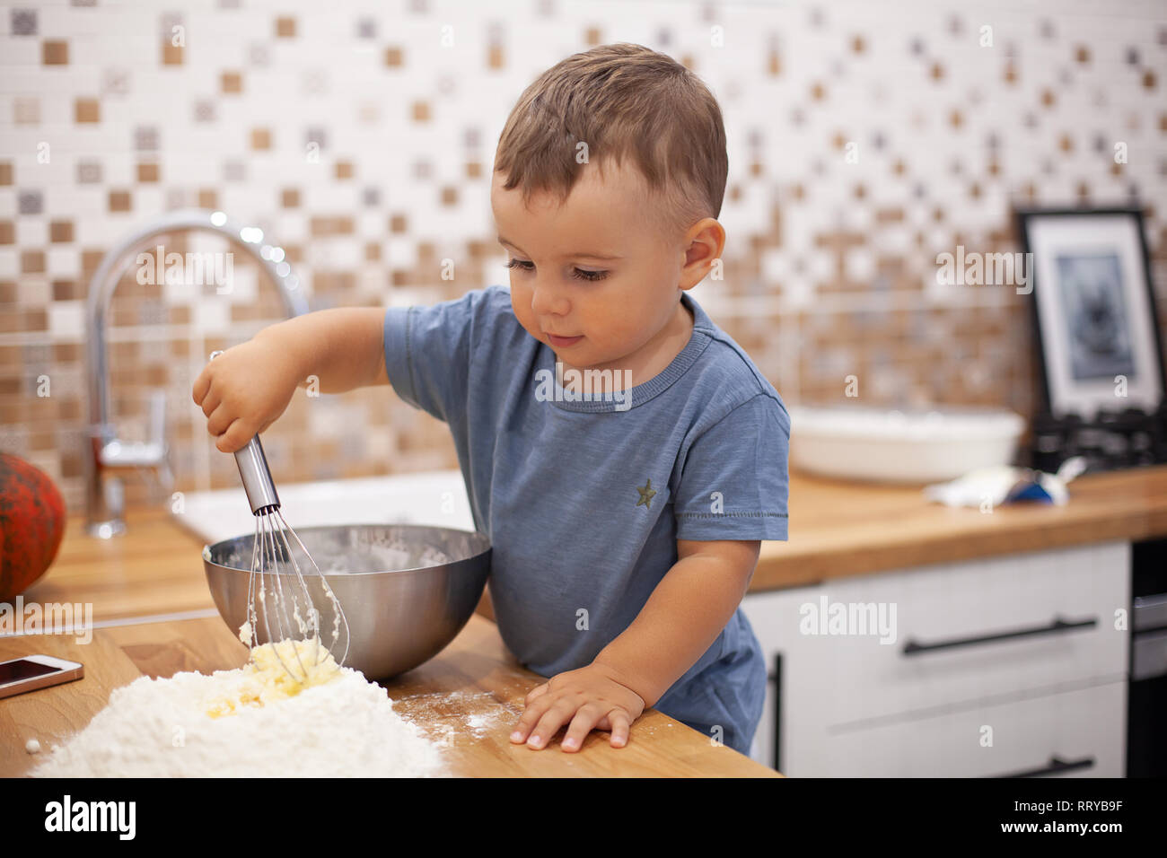 Little boy Vorbereitung Torte Teig in der Küche. Stockfoto