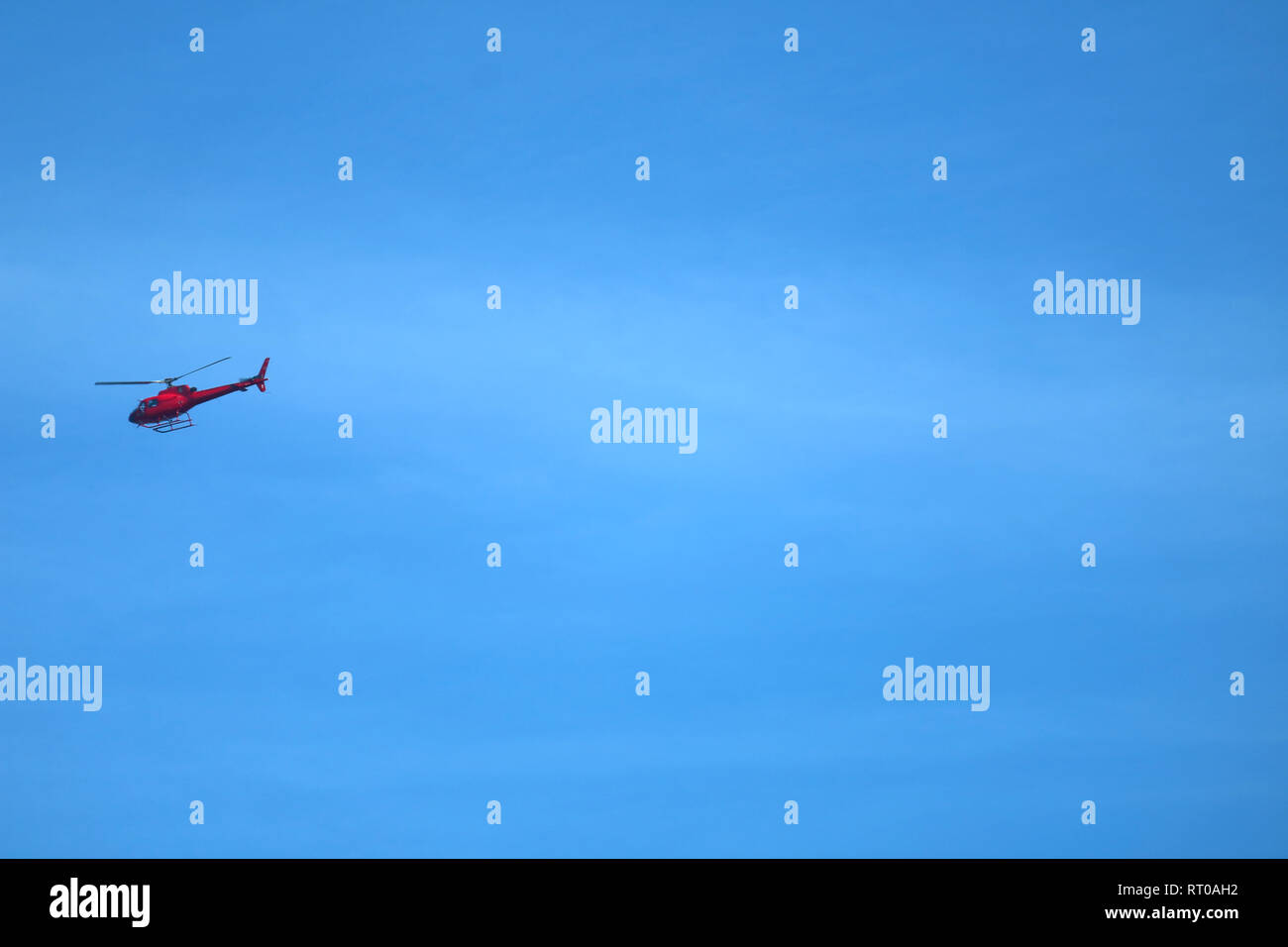 Rot Hubschrauber in vibrant blue sky von Rio de Janeiro, Brasilien fliegen Stockfoto