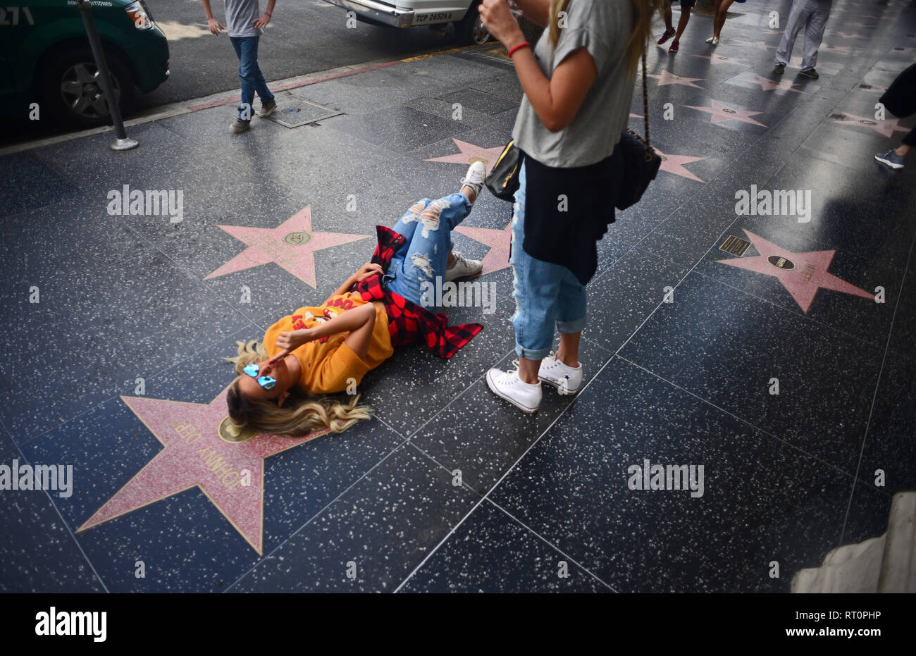 Junges Mädchen posiert neben Johnny Depp´s Stern am Hollywood Walk of Fame, Los Angeles, Kalifornien. Stockfoto