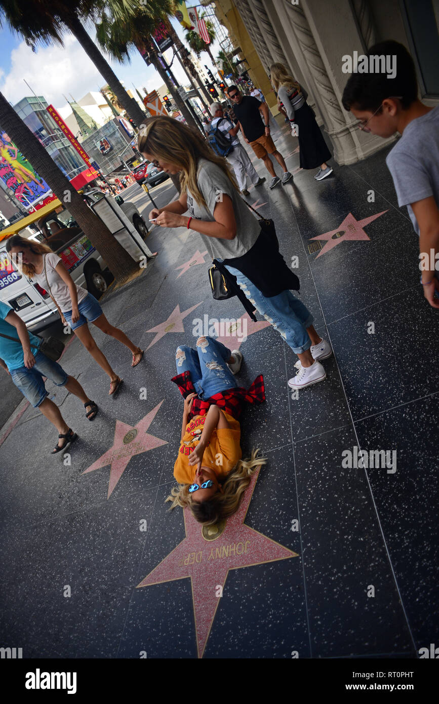 Junges Mädchen posiert neben Johnny Depp´s Stern am Hollywood Walk of Fame, Los Angeles, Kalifornien. Stockfoto