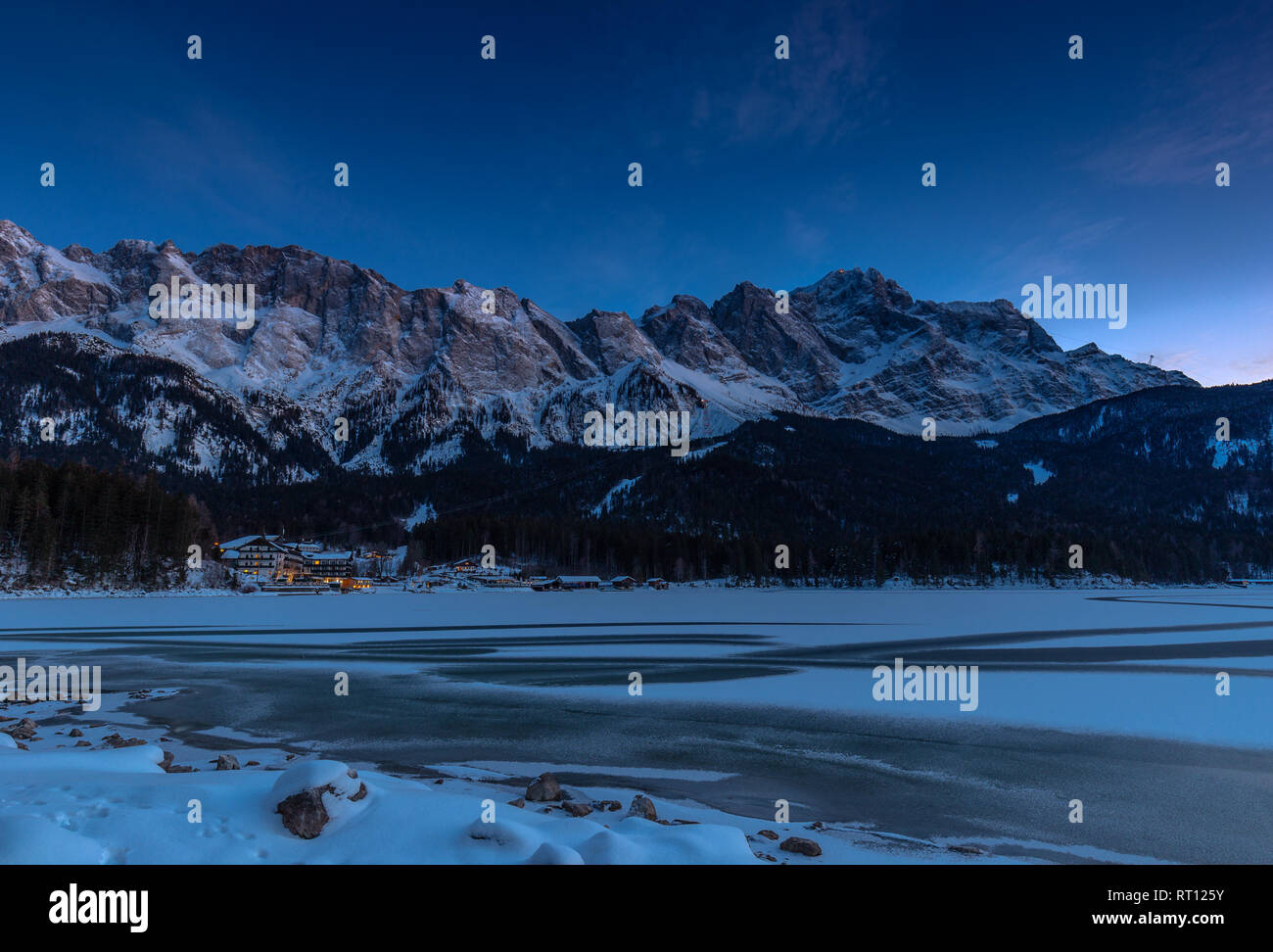 Gefroren Eibsee unter Zugspitze an einem Winterabend Stockfoto