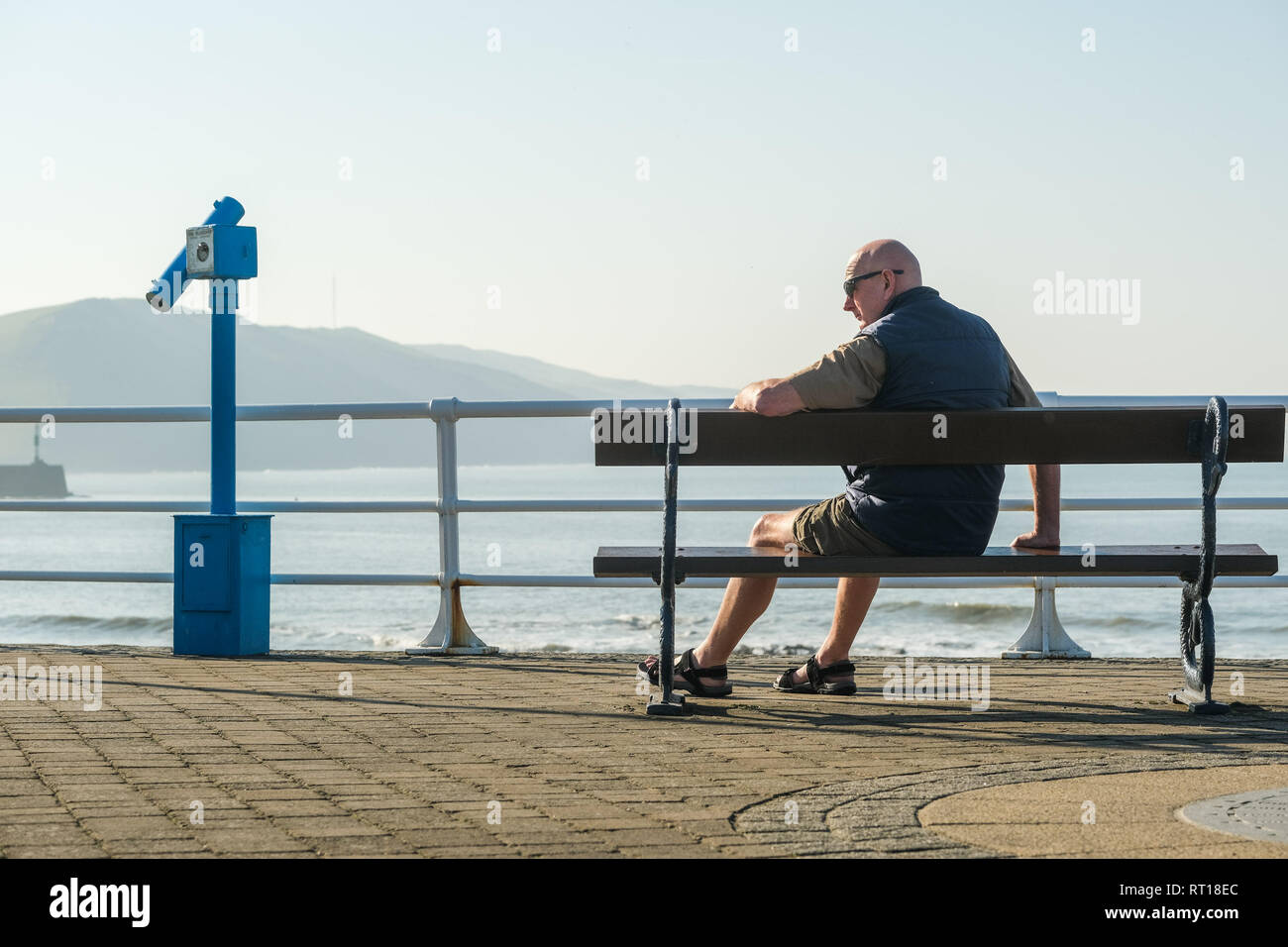 Aberystwyth Wales UK Mittwoch, den 27. Februar 2019. UK Wetter: die Leute am Strand und der Promenade in Aberystwyth am Morgen die meisten sensationell heiß und sonnig, 'Winter' Wetter, während es dauert. Das Wetter Prognose zu starten ab morgen zu verschlechtern, mit mehr typische windig und kühler Anfang März Foto erwartet: Keith Morris/Alamy leben Nachrichten Stockfoto